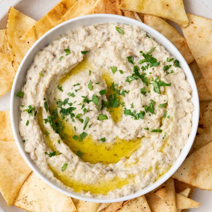 Creamy baba ghanoush topped with olive oil and parsley, served with pita bread at Shawarma House.